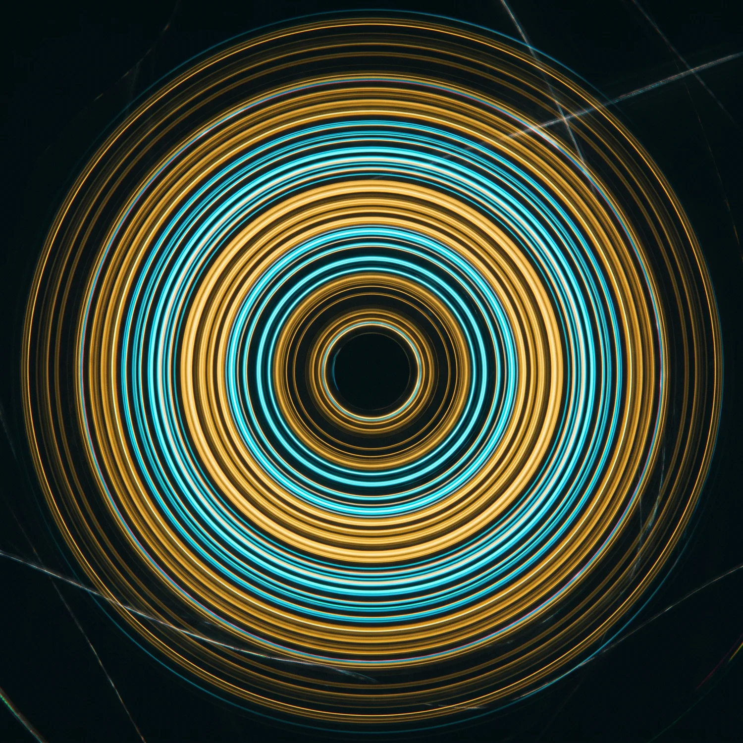 Long-exposure photograph of concentric gold and cyan light grooves, like a spinning record