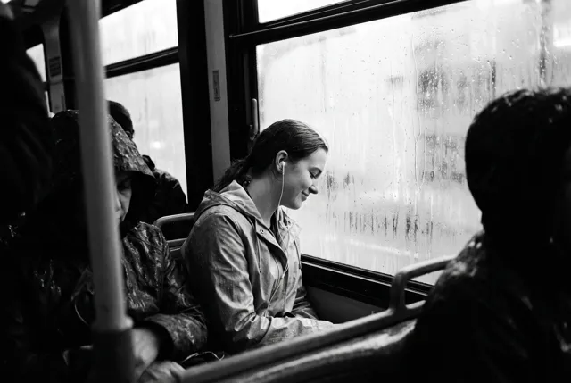 A young woman smiling on a rainy bus